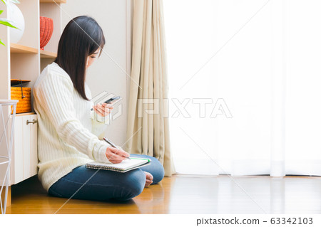Woman with smartphone and notebook copy space Woman with smartphone and notebook copy space 63342103