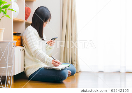 Woman with smartphone and notebook copy space Woman with smartphone and notebook copy space 63342105