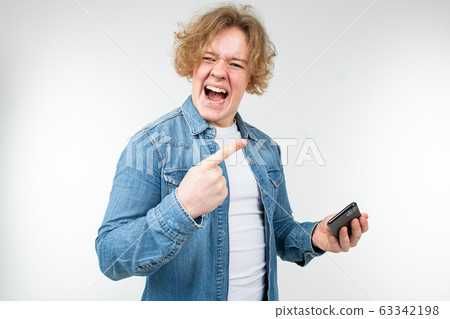 man with blond wavy hair won a phone game on a smartphone on a white background 63342198