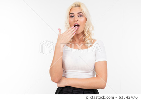 surprised girl in a white t-shirt on a white background with copy space surprised girl in a white t-shirt on a white background with copy space 63342470