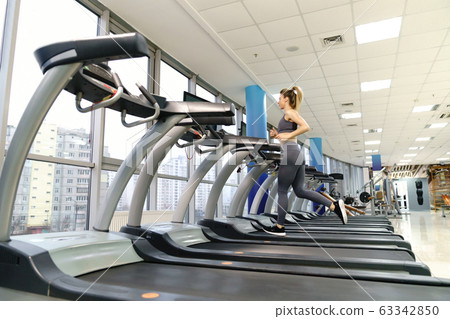 Young sporty Woman On Running Machine In Gym Young sporty Woman On Running Machine In Gym 63342850