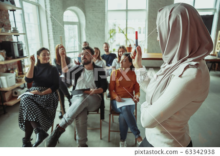 Female muslim speaker giving presentation in hall at university workshop 63342938