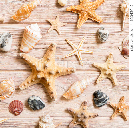 Starfish and seashells background on a wooden 63343642