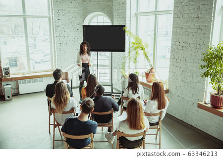 Female african-american speaker giving presentation in hall at university workshop Female african-american speaker giving presentation in hall at university workshop 63346213