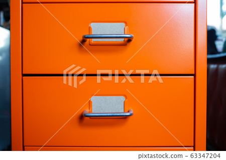 Filing cabinet with closed drawer, 2 brown cards for write letter, Orange metal colour, Administration and storage concept, closeup & Macro shot Filing cabinet with closed drawer, 2 brown cards for write letter, Orange metal colour, Administration and storage concept, closeup & Macro shot 63347204