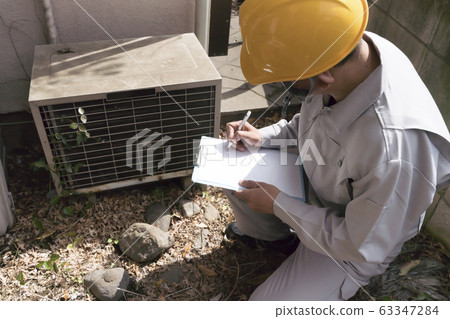 商人調查空調的老化房子室外機 63347284