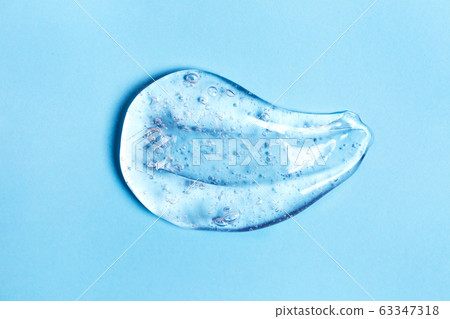 Smear of transparent gel on blue background. Smear of transparent gel on blue background. 63347318