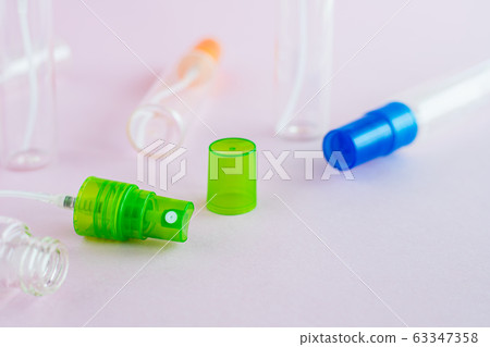 Transparent glass perfume and cosmetic spray bottle on pink background Transparent glass perfume and cosmetic spray bottle on pink background 63347358