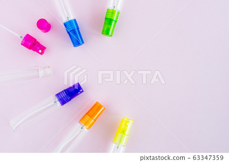 Transparent glass perfume and cosmetic spray bottle on pink background 63347359