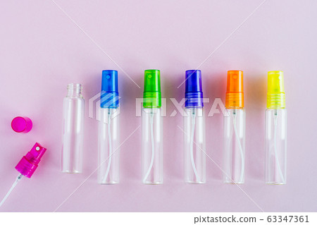 Transparent glass perfume and cosmetic spray bottle on pink background Transparent glass perfume and cosmetic spray bottle on pink background 63347361