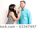 Happy man and woman. A smiling couple man and women . The girl feeds the guy fish. 63347497