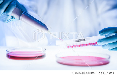 Detail of scientist working in the corona virus vaccine development laboratory research with a highest degree of protection gear. Detail of scientist working in the corona virus vaccine development laboratory research with a highest degree of protection gear. 63347564