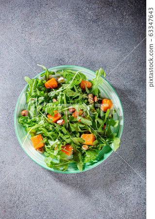 Delicious salad with arugula and baked pumpkin Delicious salad with arugula and baked pumpkin 63347643