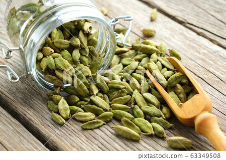 Green aromatic cardamom pods. Jar of cardamom pods 63349508