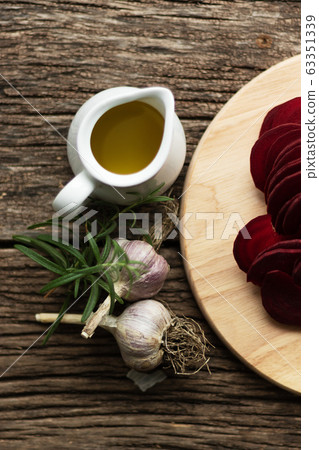 Beetroot Chips. The process of making snacks. Handmade healthy vegetable chips. On a cutting board are slices of root vegetables. Garlic and oregano spices for the dish. The preparation uses olive oil 63351339