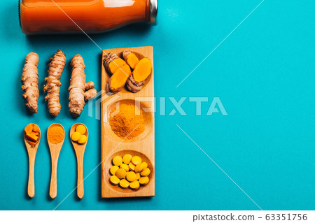 Turmeric in different conditions: fresh, dry root, pills, powder and cut plant. 63351756