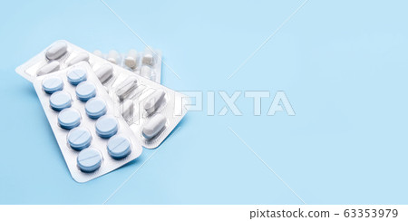 Pills in blister packs on blue background. 63353979