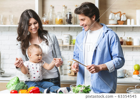 Parents preparing lunch with baby son at kitchen Parents preparing lunch with baby son at kitchen 63354545