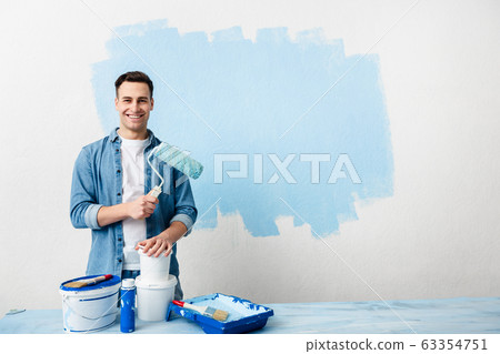 Smiling young man with tools and paint Smiling young man with tools and paint 63354751