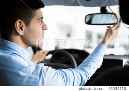 Guy Checking Mirrors Sitting In Driver's Seat Guy Checking Mirrors Sitting In Driver's Seat 63354858
