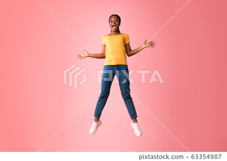 Excited Millennial Girl Jumping And Shouting Over Pink Background 63354987