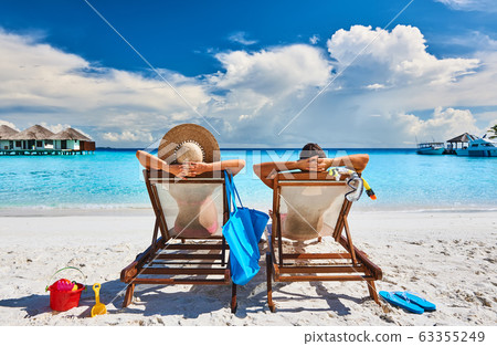 Couple in sun beds on a tropical beach 63355249