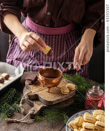 Dipping Christmas cookies in chocolate Dipping Christmas cookies in chocolate 63355507