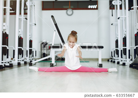 Cute little girl are engaged in gymnastics in the gym 63355667