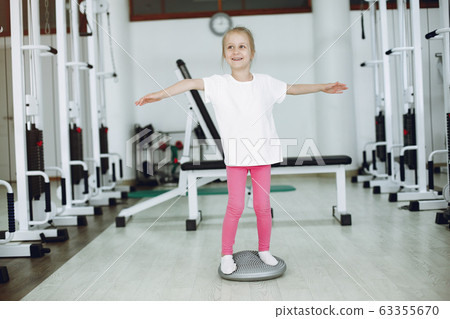 Cute little girl are engaged in gymnastics in the gym Cute little girl are engaged in gymnastics in the gym 63355670