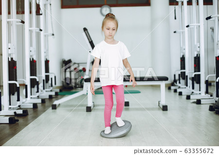 Cute little girl are engaged in gymnastics in the gym 63355672
