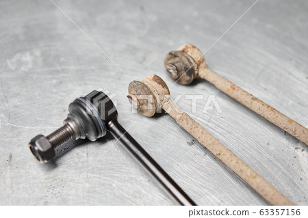 New stabilizer bar or link arm ready to replacement into car suspension on metal table in garage for repair and maintenance. Car part and suspension concept 63357156
