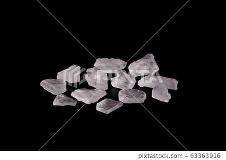 Grains of salt on a black background. Grains of salt on a black background. 63363916