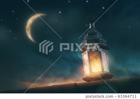 Arabic lantern with burning candle 63364711