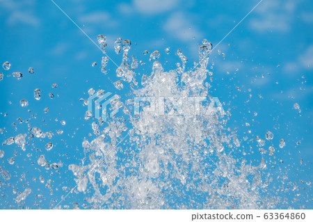Splashes of water against the blue sky background Splashes of water against the blue sky background 63364860
