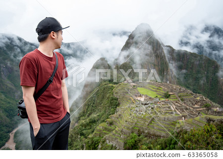 Young Asian man traveler looking at Machu Picchu 63365058