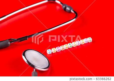 Pandemic and virus concept - Coronavirus text with syringe and phonendoscope on red background. Novel coronavirus Covid-19. Top view 63366262