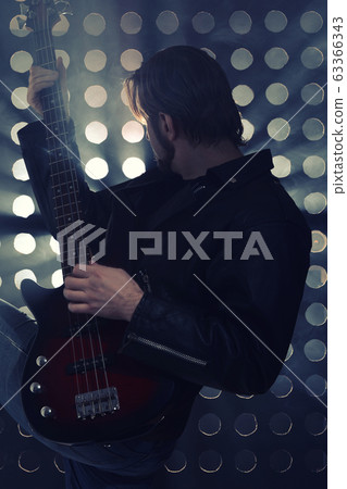 Bassist playing bass guitar in smoke. backlight 63366343