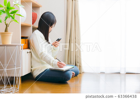 Woman with smartphone and notebook copy space Woman with smartphone and notebook copy space 63366438