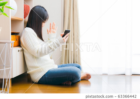 A woman who shakes her smartphone Video call App Selfie Selfie Delivery Copy space A woman who shakes her smartphone Video call App Selfie Selfie Delivery Copy space 63366442