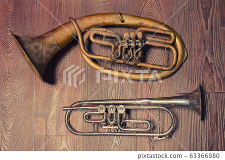 old brass wind instrument and horn on a wooden old brass wind instrument and horn on a wooden 63366980