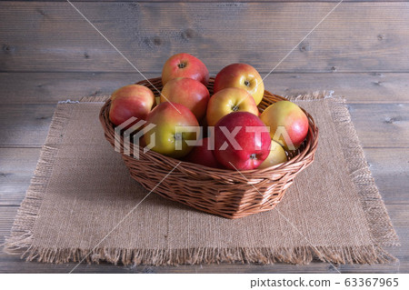 apples in a basket on a table 63367965