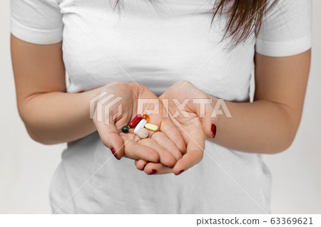 large amount of pills in female hands large amount of pills in female hands 63369621