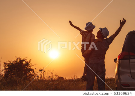 Father and son playing in the park at the sunset Father and son playing in the park at the sunset 63369624