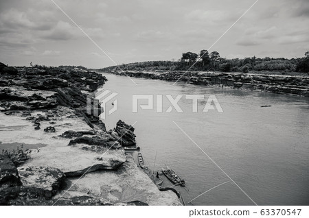 Canyon cliff shoreline of Mekong river and local boat 63370547