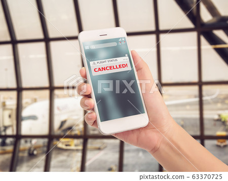 flight cancellation concept. announces message for flight schedule change information alert on smartphone application with airport terminal at background. flight cancellation concept. announces message for flight schedule change information alert on smartphone application with airport terminal at background. 63370725