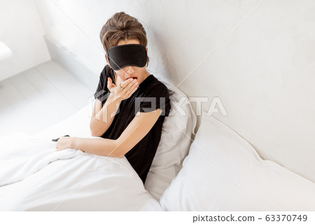 Woman in sleeping mask in bed Woman in sleeping mask in bed 63370749