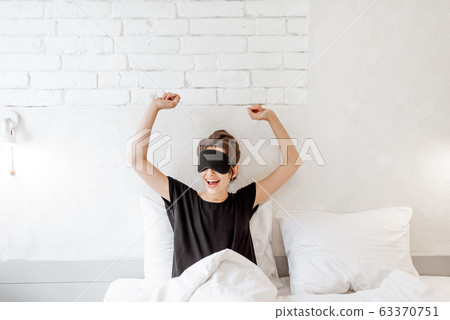 Woman waking up in bed Woman waking up in bed 63370751