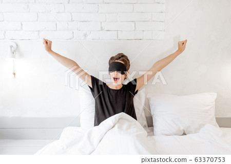 Woman waking up in bed Woman waking up in bed 63370753