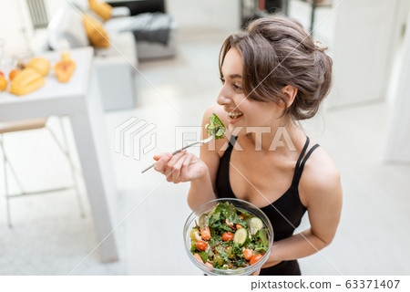 Sports woman with healthy food at home Sports woman with healthy food at home 63371407