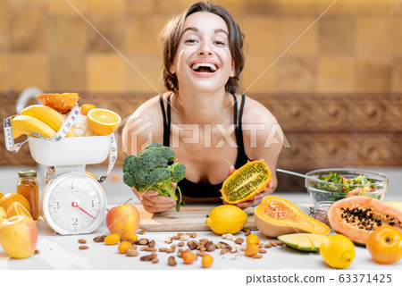 Sports woman with healthy food on the kitchen Sports woman with healthy food on the kitchen 63371425